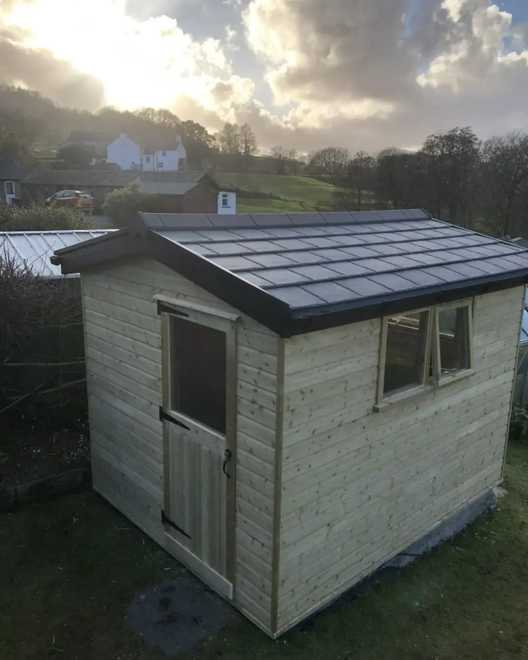 Timber garden shed with dark pitched roof